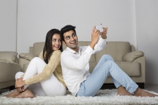 couple clicking picture with mobile phone at home