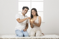 newly wed couple at new home with piggy bank