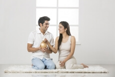 newly wed couple at new home with piggy bank