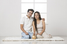 newly wed couple at new home with piggy bank