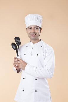 chef posing with spatula and ladle
