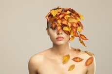 model covered with leaves portraying autumn