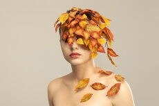 model covered with leaves portraying autumn