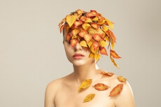 model covered with leaves portraying autumn