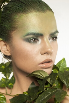woman covered with green leaves