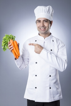 chef posing with fresh carrots 