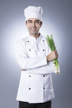 chef posing with spring onions 