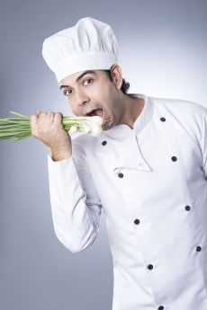 chef posing with spring onions 