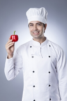 chef posing with red capsicum
