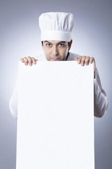 chef posing with placard