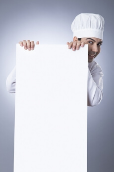 chef posing with placard
