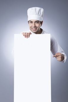 chef pointiing at placard