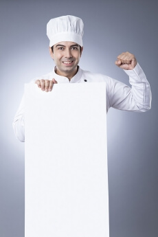 chef posing with placard