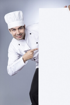 chef pointiing at placard