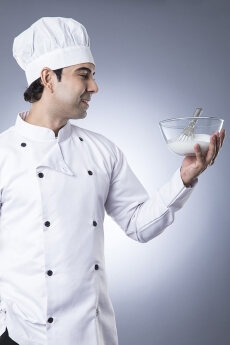 chef posing with egg beater