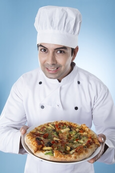 chef posing with pizza