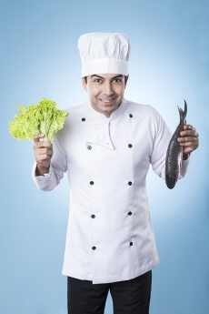 chef posing with fish and lettuce