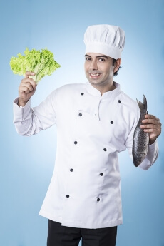 chef posing with fish and lettuce