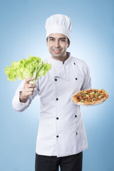 chef posing with pizza and lettuce