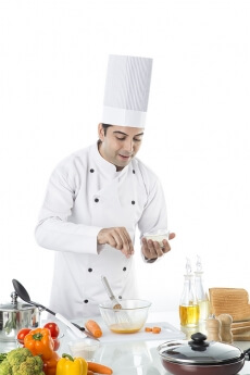 chef adding salt to the bowl 
