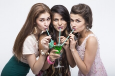 young stylish girls sipping from the mocktail while posing