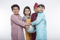 four kids carrying globe while posing
