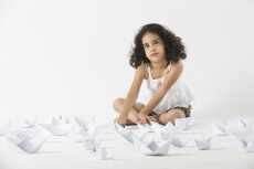 cute little girl playing with paper boat 