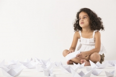 cute little girl playing with paper boat 