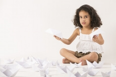 cute little girl playing with paper boat 