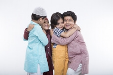kids from different religions hugging each other 