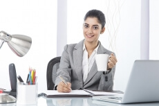 corporate woman having coffee while working 