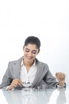 woman in formals checking money with magnifying glass