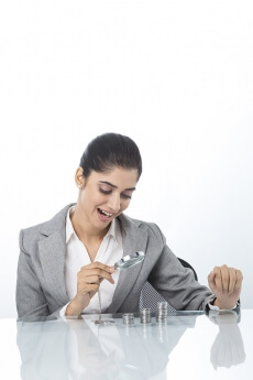 woman in formals checking money with magnifying glass