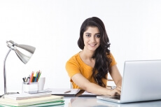woman sitting and working on laptop 