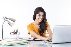 woman sitting and working on laptop 