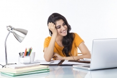 woman sitting and working on laptop 