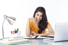 woman sitting and working on laptop 