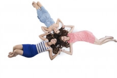 three girls lying on floor and posing