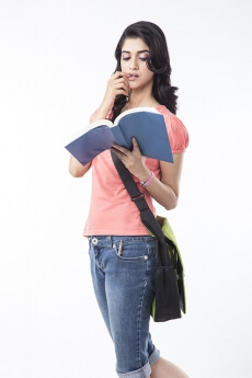 college girl posing while holding a text book