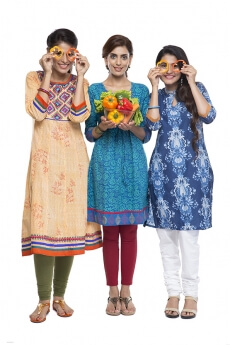 three women standing together holding vegetable in hand