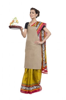 women wearing apron and tossing vegetables in fry pan