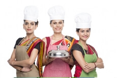 women wearing apron with kitchen utensils