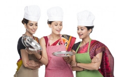 women wearing apron with kitchen utensils
