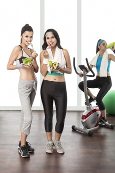 young girls having fruit salad in gym