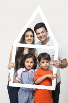 family posing with house shaped frame