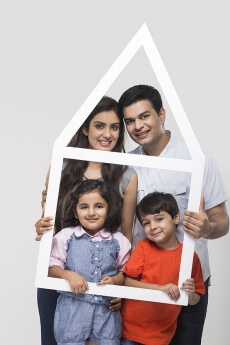 family posing with house shaped frame