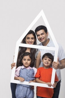 family posing with house shaped frame