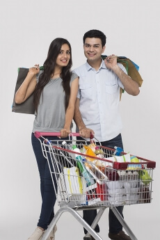 Couple posing with shopping bags and shopping kart