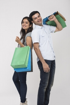 Couple posing with shopping bags while looking at camera