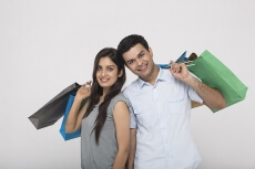 Couple posing with shopping bags while looking at camera